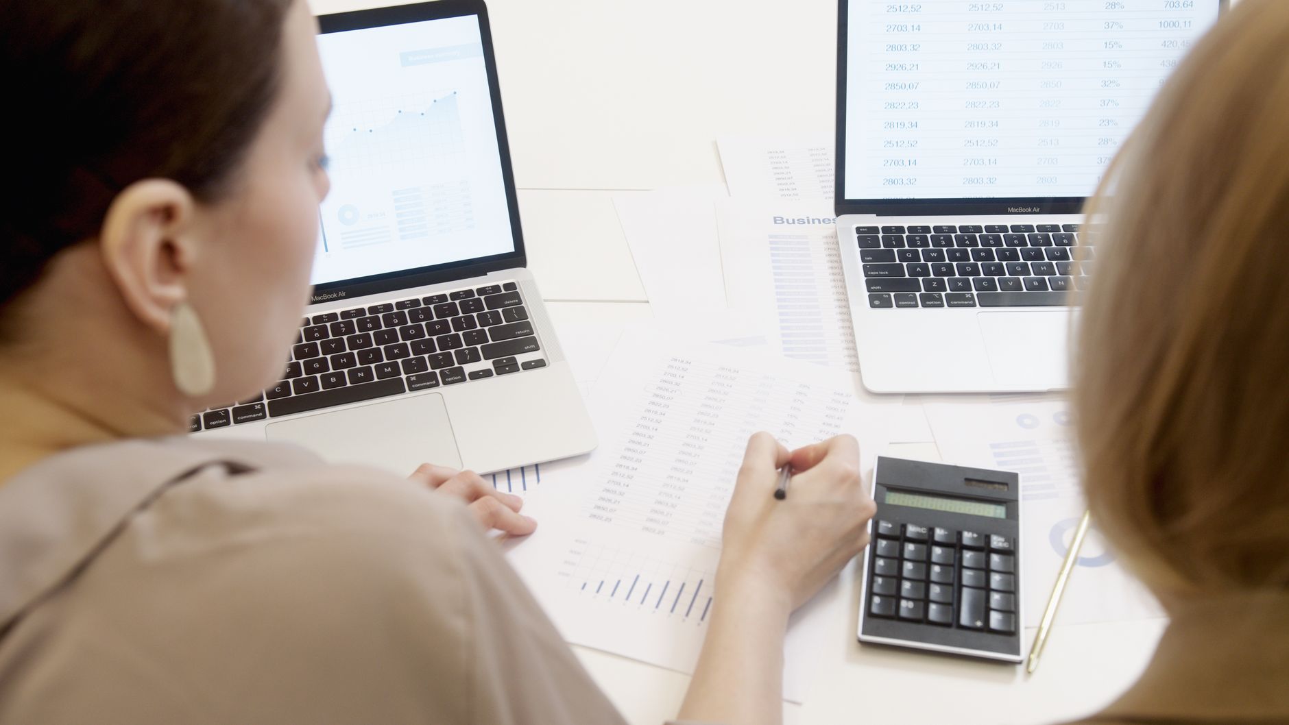 Spreadsheets, charts and a calculator on a desk